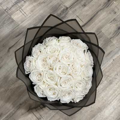 Round bouquet of white roses wrapped in black paper