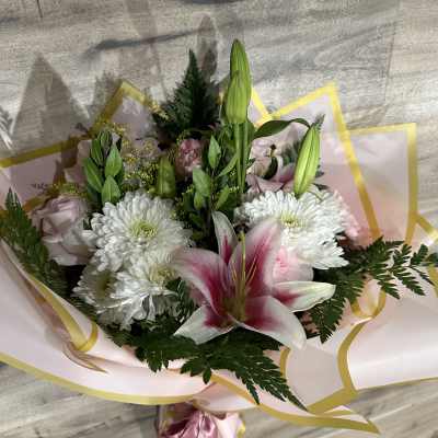 Bouquet of white chrysanthemums and pink lilies wrapped in pink paper