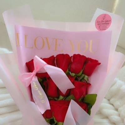 Bouquet of red roses wrapped in pink paper with a ribbon