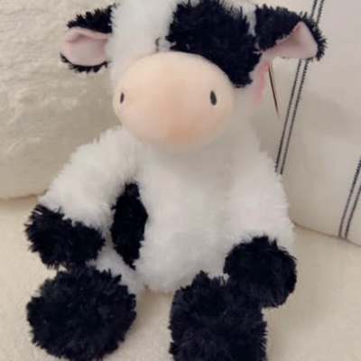 Plush cow toy sitting on a chair