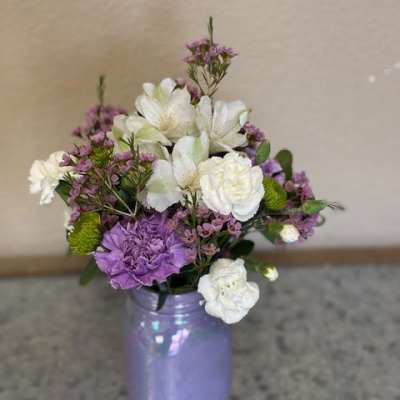 Purple and white bouquet in a lavender vase