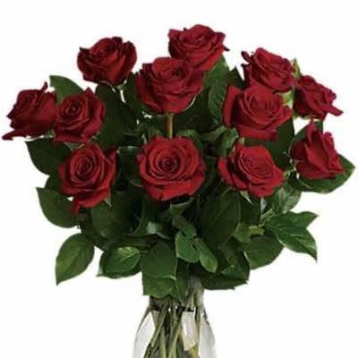 Dozen long-stem red roses arranged in a clear glass vase.