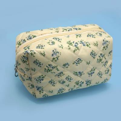 Quilted floral zip pouch on a blue background