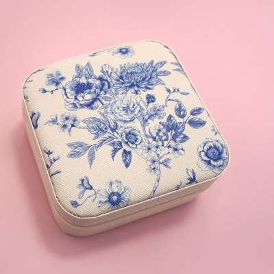 Floral-patterned square zip case on a pink background