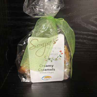 Bag of creamy caramels tied with a green ribbon