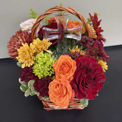 Basket arrangement of roses and chrysanthemums with a clear glass cross