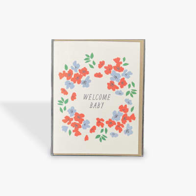 Welcome Baby card with a floral wreath in red, blue, and green