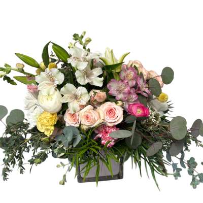 Mixed bouquet of roses, lilies, and alstroemeria in a square vase