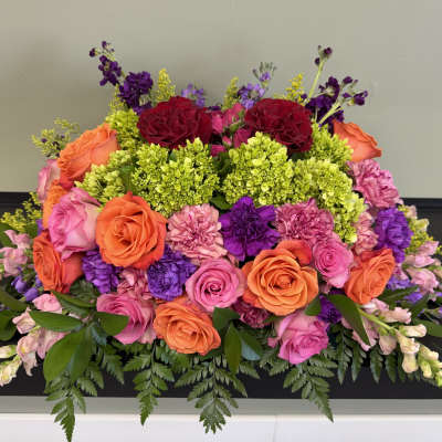 Colorful floral arrangement with roses, carnations, and purple blooms