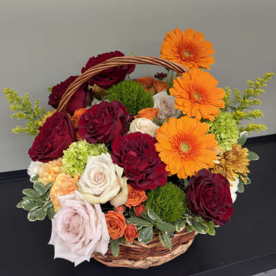 Basket of mixed roses and orange gerbera daisies