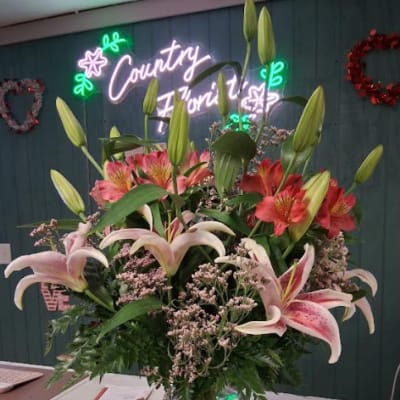 Tall bouquet of lilies and alstroemeria in a glass vase