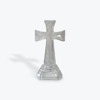Clear glass cross-shaped decorative piece on a white background