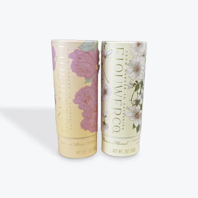 Two floral-scented candle tubes with rose and daisy designs