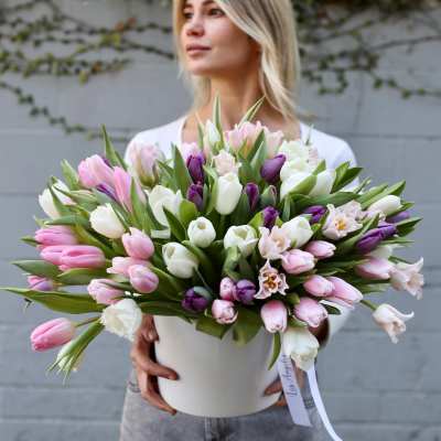 Large bouquet of pink, white, and purple tulips in a white hatbox