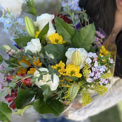 Mixed bouquet of white roses, yellow daisies, and blue flowers