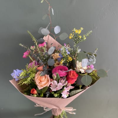 Hand-tied bouquet of mixed pink, peach, and purple flowers