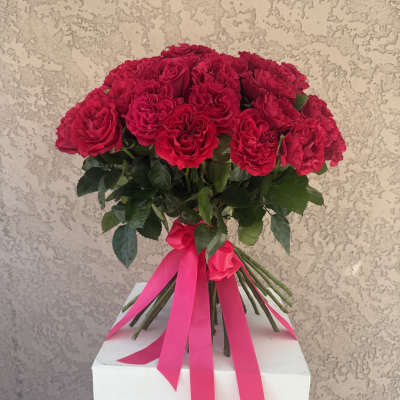 Bouquet of red roses tied with a pink ribbon