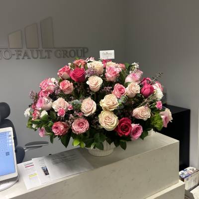 Large pink and cream rose arrangement in a white vase