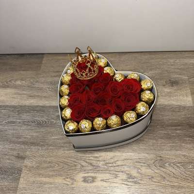 Heart-shaped box of red roses with gold-wrapped chocolates and a crown topper