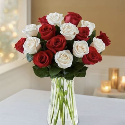 Red and white roses arranged in a clear glass vase