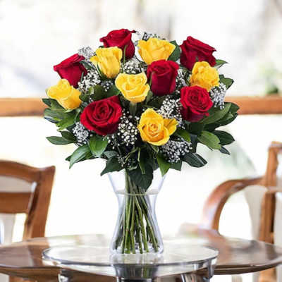Bouquet of red and yellow roses in a clear glass vase