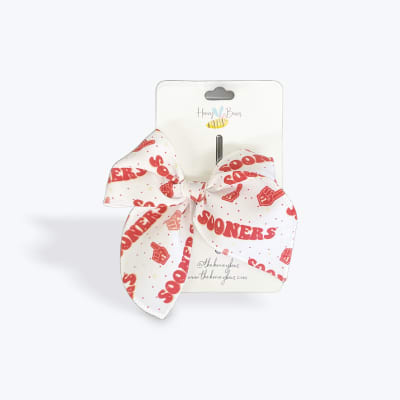 White hair bow with red text on retail packaging