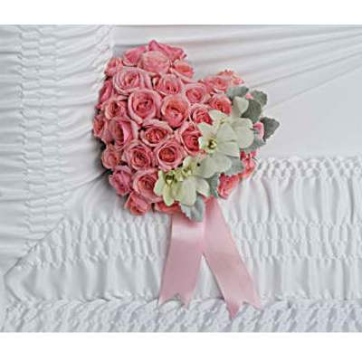 Pink rose heart arrangement with orchids and pink ribbon on white casket lining