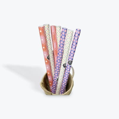 Basket holding rolls of patterned gift wrap
