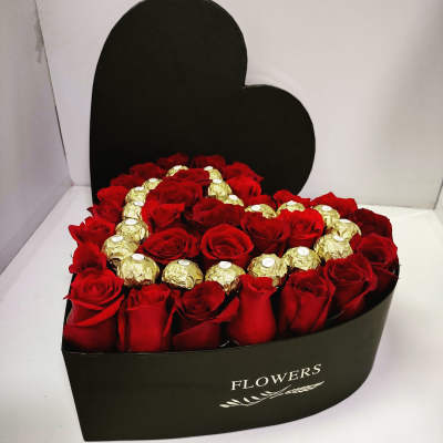 Heart-shaped box of red roses with gold-wrapped chocolates