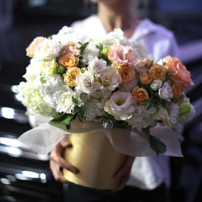Large bouquet of white and peach roses in a gold box