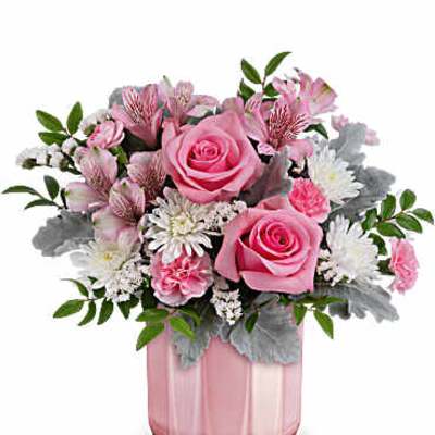 Pink roses and mixed blooms in a pink glass vase