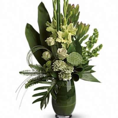 Green floral arrangement in a tall vase with white blooms
