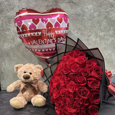 Red rose bouquet with a teddy bear and heart-shaped Valentine balloon