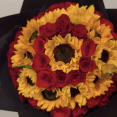 Round bouquet of red roses and yellow sunflowers wrapped in black paper