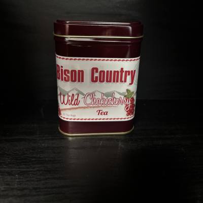 Maroon tin of Wild Chokecherry tea on a dark surface
