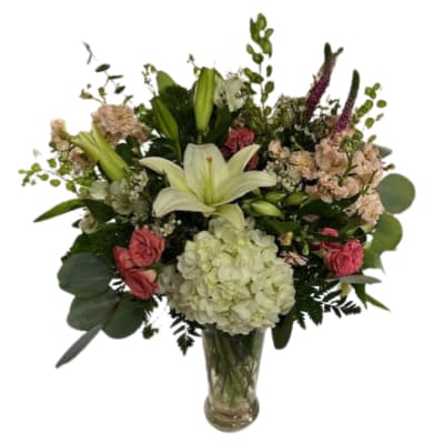 Bouquet of lilies, hydrangea, and pink flowers in a glass vase