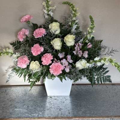 Pink carnations and white roses in a white vase