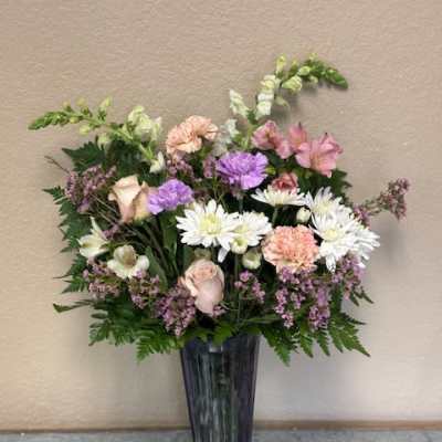 Mixed pastel bouquet in a tall dark vase