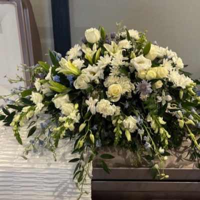 Large white floral spray on a casket