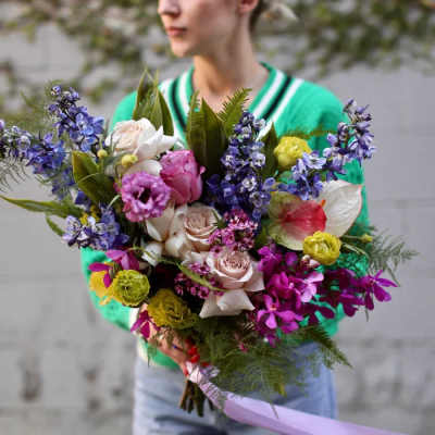 Person holding a colorful bouquet of mixed flowers
