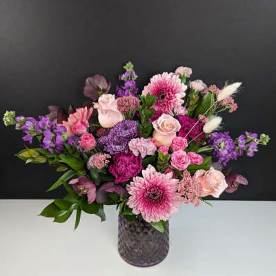 Pink and purple mixed bouquet in a textured glass vase