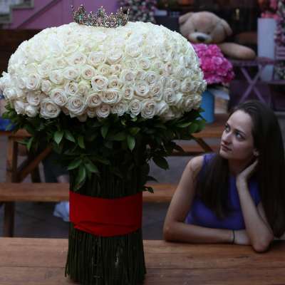 Large white rose arrangement with a jeweled crown on top