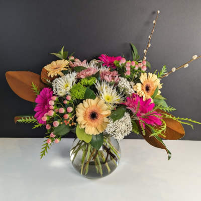 Mixed bouquet of gerbera daisies and chrysanthemums in a glass vase