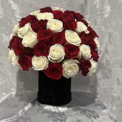 Red and white rose arrangement in a black box