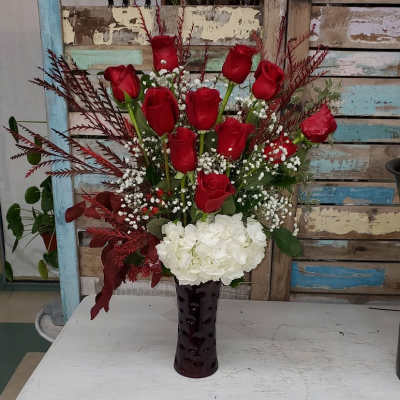 Red roses and white hydrangea in a dark vase