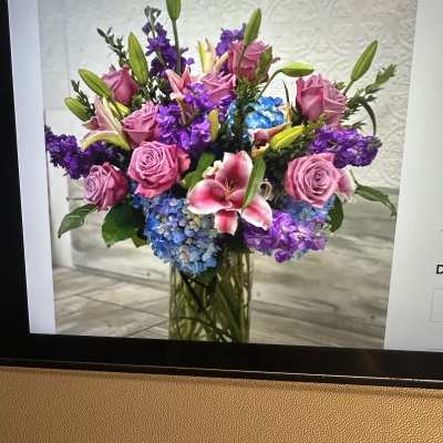 Tall vase arrangement with pink roses, lilies, purple stock, and blue hydrangeas