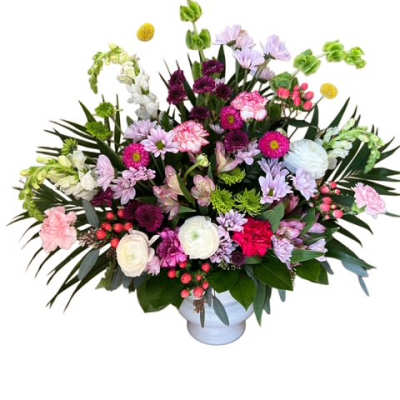 Large mixed bouquet in a white vase with pink, purple, and white blooms