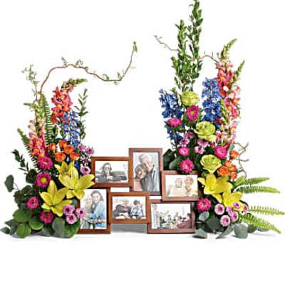 Colorful floral memorial display with framed photos