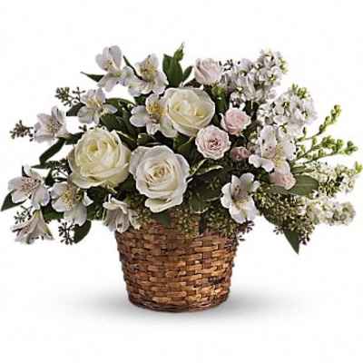 White and pale pink flower arrangement in a woven basket
