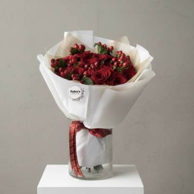 Red rose bouquet wrapped in white paper and tied with a red ribbon